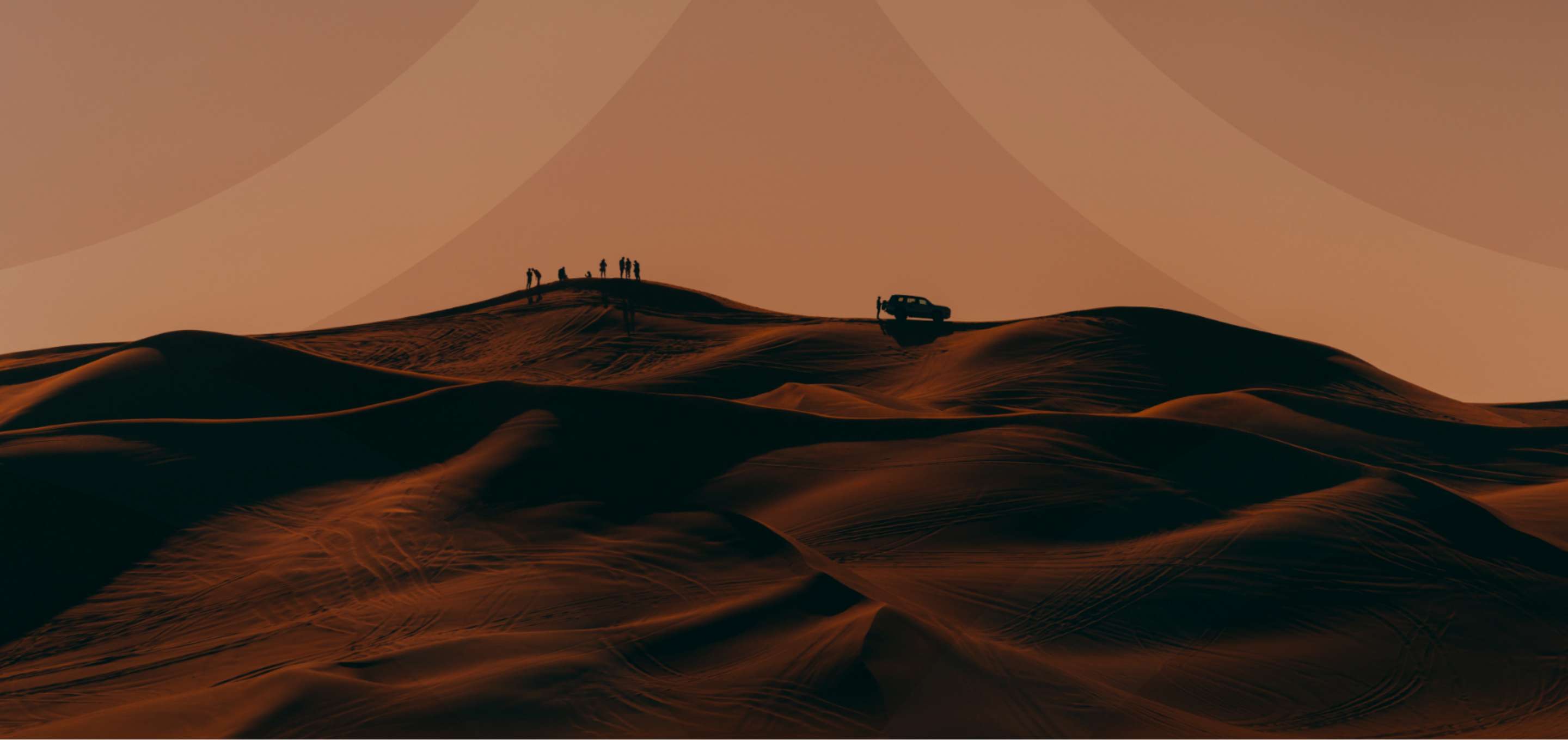 a desert with people and a car in the distance