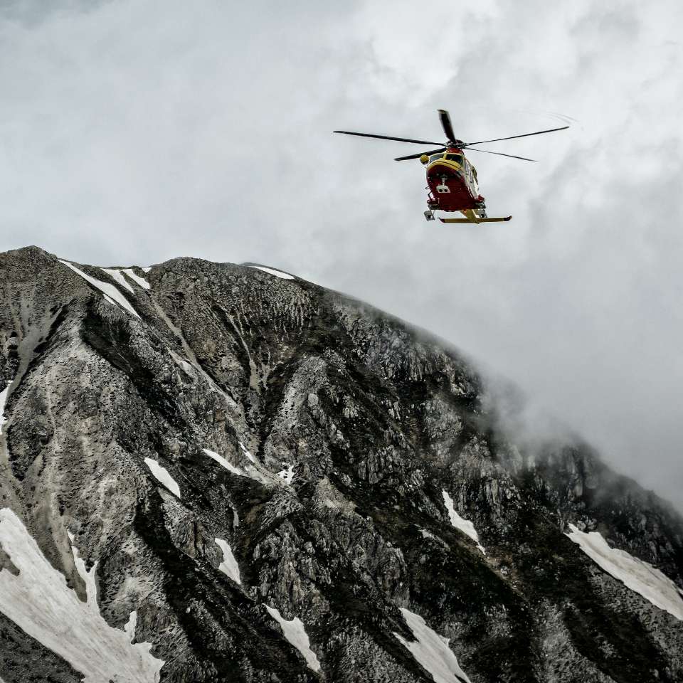 helicopter flying over a mountain